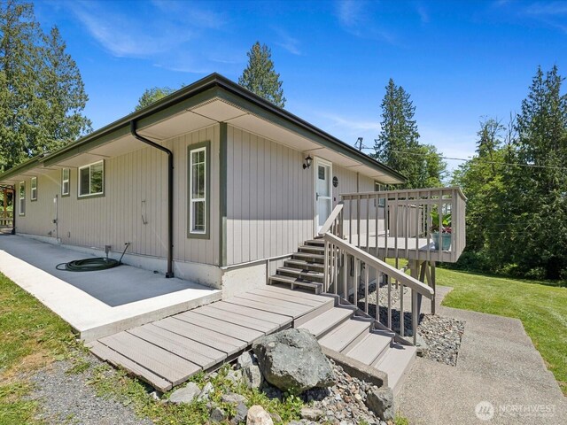 7315 294th St NE, Arlington, WA 98223 - view of front facade featuring a patio area, a deck, a front yard, and stairs