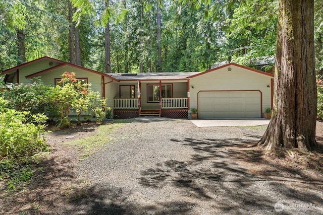 447 E Pointes Dr E, Shelton, WA 98584 - view of front of home featuring covered porch, gravel driveway, and a garage