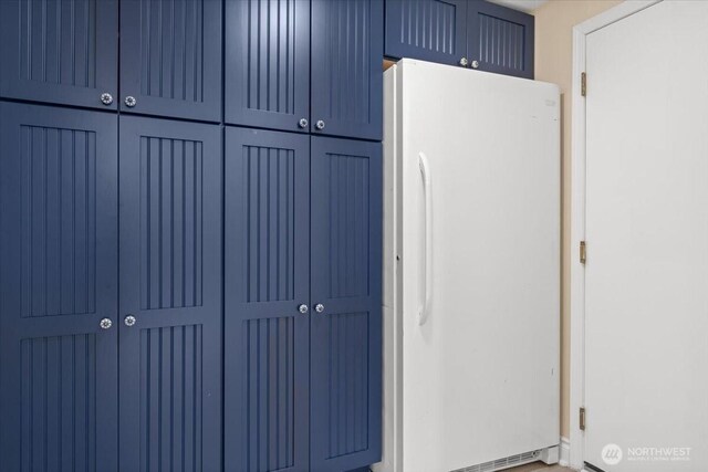 447 E Pointes Dr E, Shelton, WA 98584 - kitchen with freestanding refrigerator and blue cabinetry