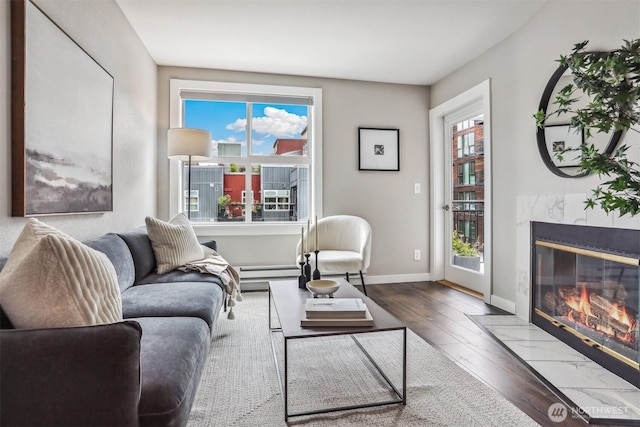 769 Hayes St Unit 504, Seattle, WA 98109 - living area with a high end fireplace, hardwood / wood-style flooring, baseboards, and a baseboard heating unit