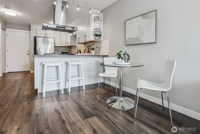 769 Hayes St Unit 504, Seattle, WA 98109 - kitchen featuring island range hood, stainless steel fridge, open shelves, decorative backsplash, and white cabinetry