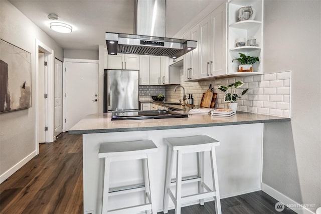 769 Hayes St Unit 504, Seattle, WA 98109 - kitchen featuring stainless steel fridge, island exhaust hood, a sink, baseboards, and tasteful backsplash