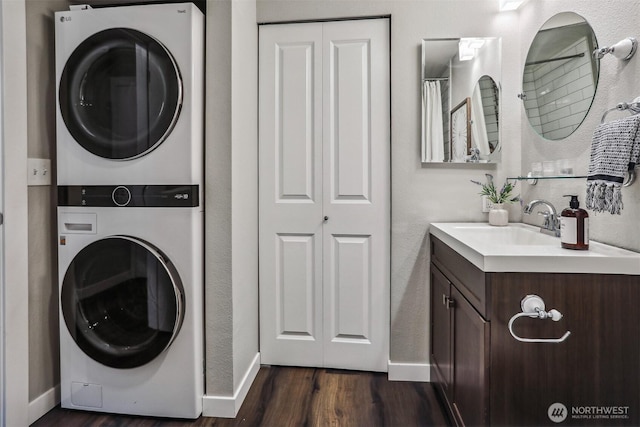769 Hayes St Unit 504, Seattle, WA 98109 - washroom featuring stacked washer / drying machine, a sink, and baseboards