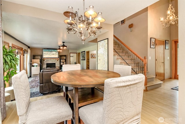 2634 59th Ave NW, Olympia, WA 98502 - dining room with a chandelier, light wood-style floors, stairs, and a fireplace
