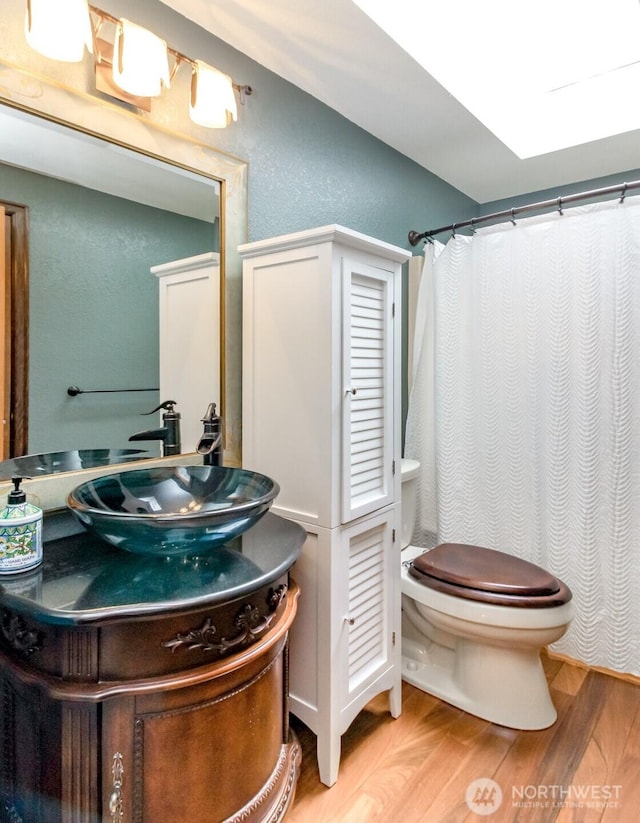 2634 59th Ave NW, Olympia, WA 98502 - bathroom with wood finished floors, vanity, a shower with curtain, and a textured wall