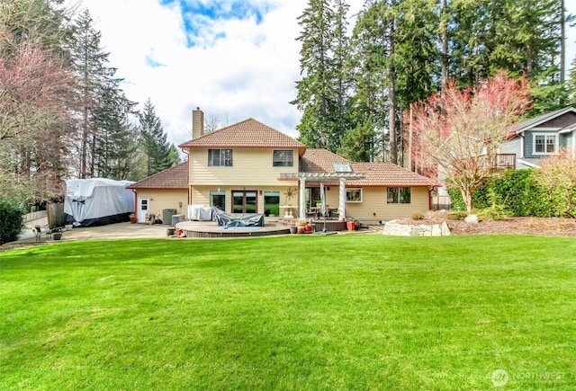 2634 59th Ave NW, Olympia, WA 98502 - back of property featuring a chimney, a lawn, a wooden deck, and a tiled roof