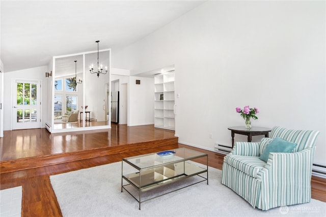 living area with a chandelier, wood finished floors, high vaulted ceiling, baseboards, and a baseboard radiator