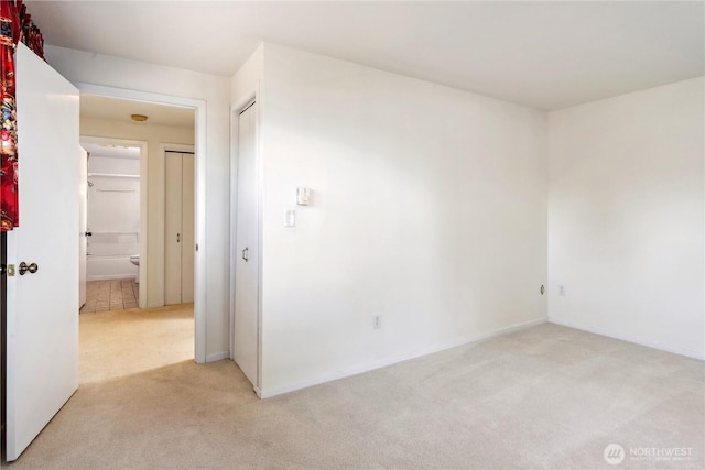 empty room with light colored carpet and baseboards
