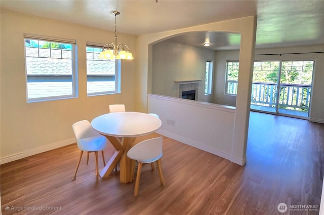 18501 SE Newport Way Unit H335, Issaquah, WA 98027 - dining room featuring wood finished floors, a tiled fireplace, plenty of natural light, and baseboards