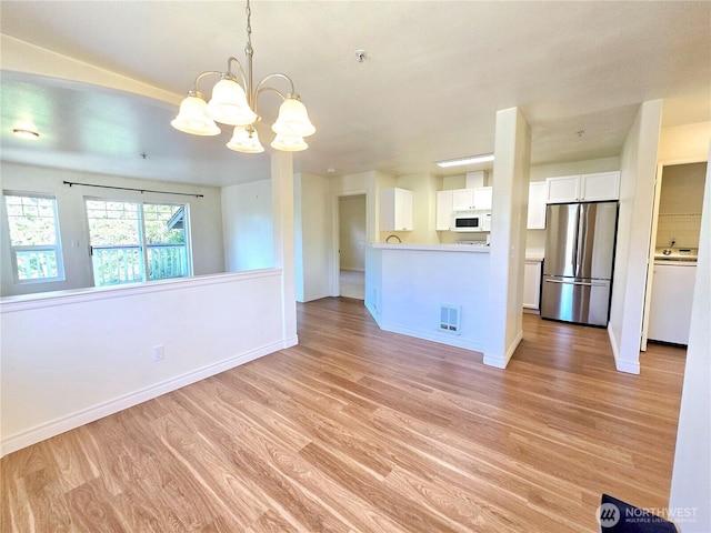 18501 SE Newport Way Unit H335, Issaquah, WA 98027 - unfurnished living room with light wood-style floors, a chandelier, baseboards, and washer / clothes dryer