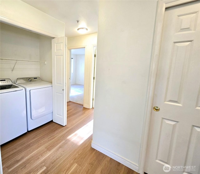 18501 SE Newport Way Unit H335, Issaquah, WA 98027 - washroom featuring light wood-style flooring, washer and dryer, and baseboards