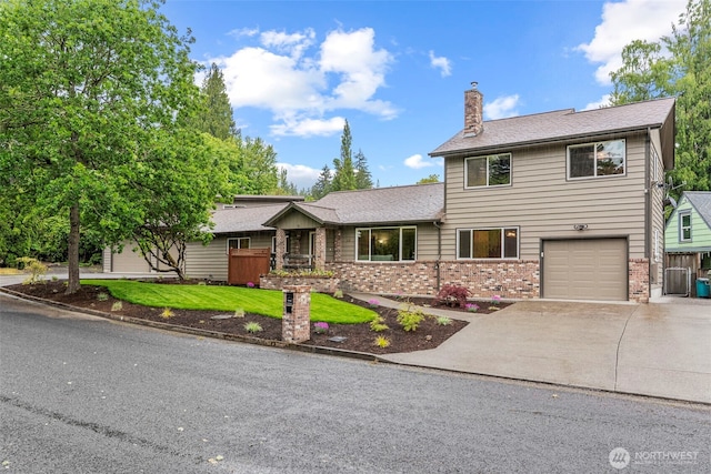 58 Pacific Pl, Longview, WA 98632 - view of front facade with a chimney, brick siding, driveway, an attached garage, and a front yard