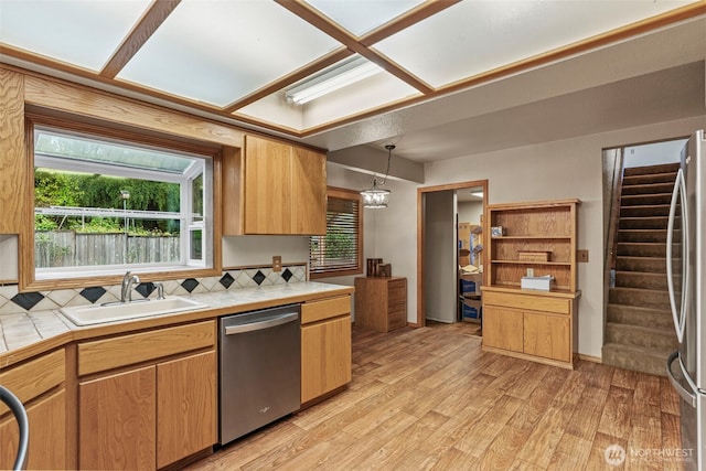 58 Pacific Pl, Longview, WA 98632 - kitchen with appliances with stainless steel finishes, tile counters, a sink, light wood finished floors, and decorative light fixtures