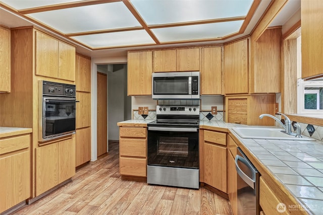 58 Pacific Pl, Longview, WA 98632 - kitchen with appliances with stainless steel finishes, tile counters, a sink, light wood-type flooring, and light brown cabinets