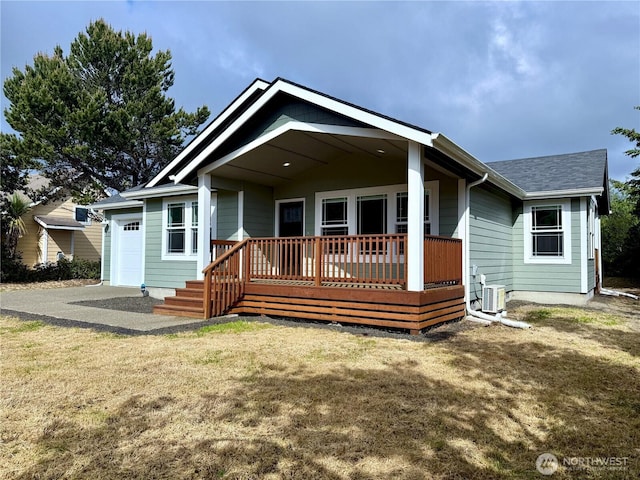 335 N Wynoochee Dr SW, Ocean Shores, WA 98569 - back of property featuring covered porch, central AC, a yard, an attached garage, and roof with shingles