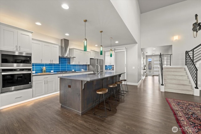 23145 65th St E, Buckley, WA 98321 - kitchen featuring wall chimney range hood, a barn door, dark wood-style floors, baseboards, and recessed lighting