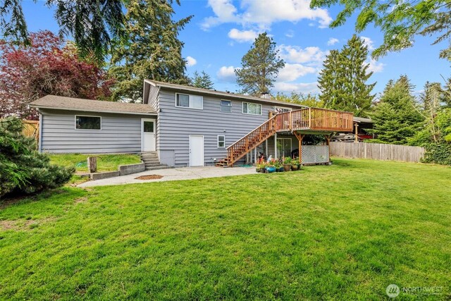 back of property with stairway, a wooden deck, a patio area, and entry steps