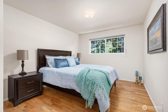 bedroom with light wood finished floors and baseboards