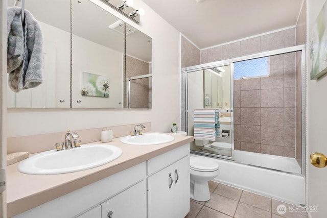 bathroom featuring double vanity, tile patterned flooring, shower / bath combination with glass door, and toilet
