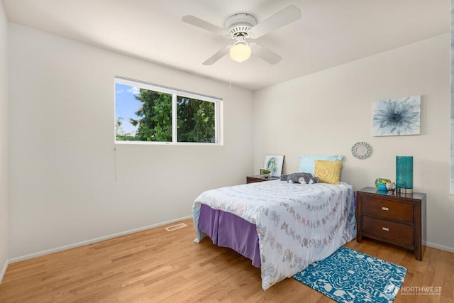 bedroom with light wood-style floors, baseboards, and ceiling fan