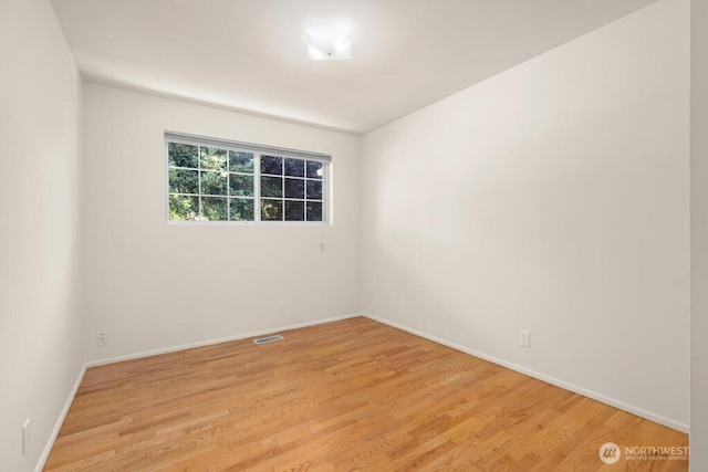 empty room featuring light wood-style flooring and baseboards