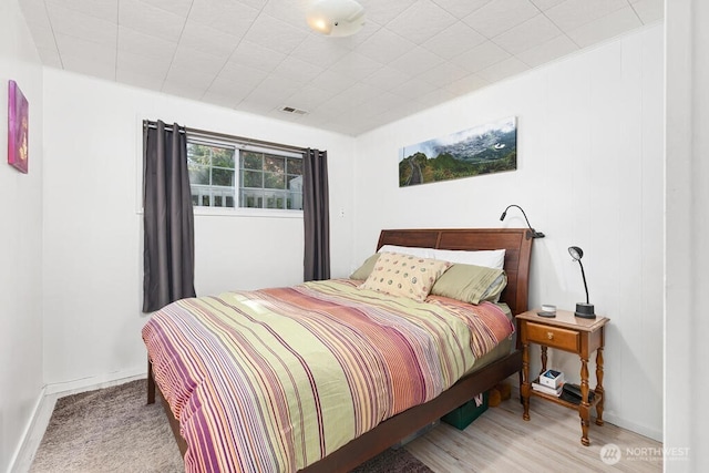 bedroom with wood finished floors and baseboards