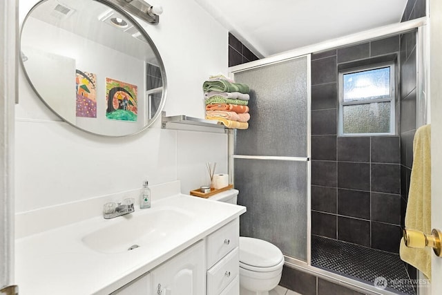 bathroom featuring a shower stall, toilet, and vanity