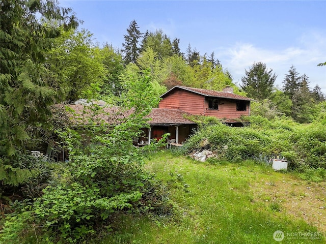 6811 128th St E, Puyallup, WA 98373 - view of side of home with a chimney and a view of trees