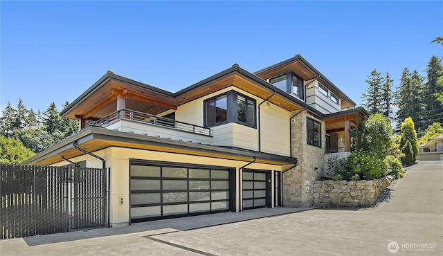 9120 NE 25th Pl, Clyde Hill, WA 98004 - contemporary house featuring a balcony, stone siding, a garage, and driveway