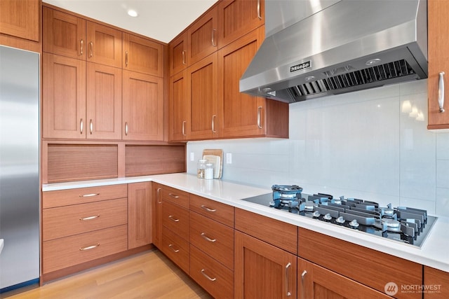 9120 NE 25th Pl, Clyde Hill, WA 98004 - kitchen with wall chimney range hood, built in fridge, gas stovetop, light countertops, and brown cabinetry