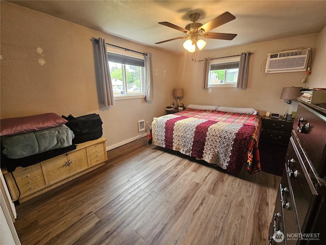 10915 Davisson Rd SW, Lakewood, WA 98499 - bedroom with wood finished floors, multiple windows, a wall mounted AC, and baseboards