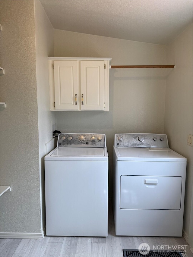 1710 263rd St, Ocean Park, WA 98640 - laundry area featuring cabinet space, washing machine and dryer, light wood finished floors, and baseboards