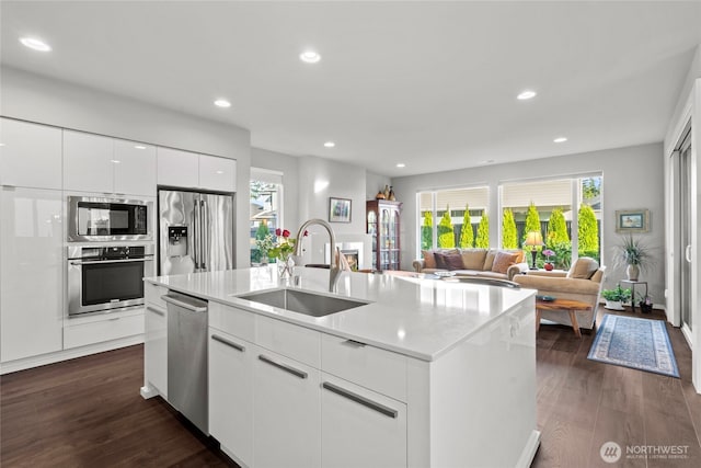 2553 Vardon Cir SW, Port Orchard, WA 98367 - kitchen with appliances with stainless steel finishes, a sink, an island with sink, white cabinetry, and dark wood-style flooring