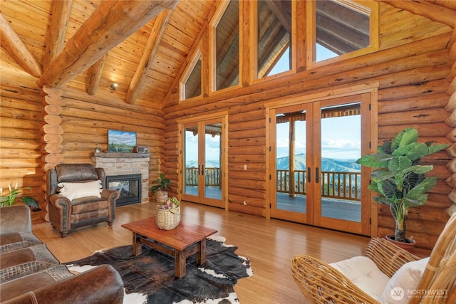 1831 Cottontail Ln, Chelan, WA 98816 - living area with french doors, wooden ceiling with exposed beams, high vaulted ceiling, light wood finished floors, and a stone fireplace