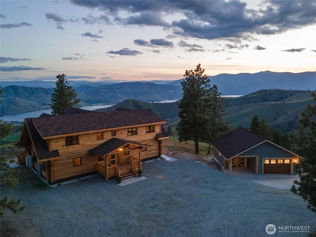 1831 Cottontail Ln, Chelan, WA 98816 - view of front of house with driveway, a mountain view, an outbuilding, and a garage