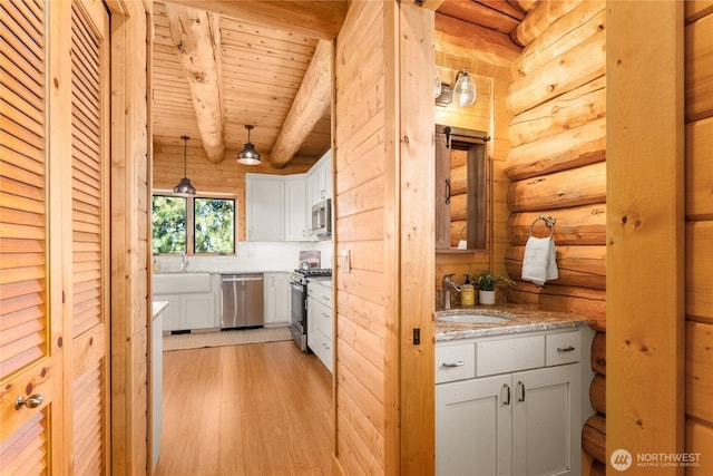 1831 Cottontail Ln, Chelan, WA 98816 - kitchen featuring stainless steel appliances, a sink, wood ceiling with exposed beams, log walls, and light wood-style flooring