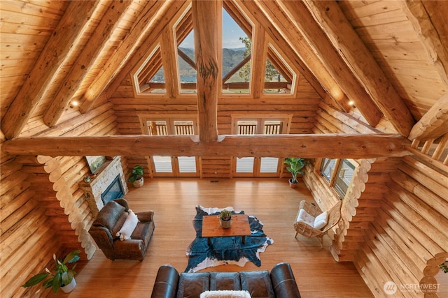 1831 Cottontail Ln, Chelan, WA 98816 - living room featuring rustic walls, high vaulted ceiling, wooden ceiling with exposed beams, wood finished floors, and a stone fireplace