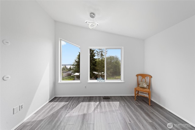 15396 Dewey Crest Ln, Anacortes, WA 98221 - empty room featuring wood finished floors, lofted ceiling, baseboards, and a chandelier