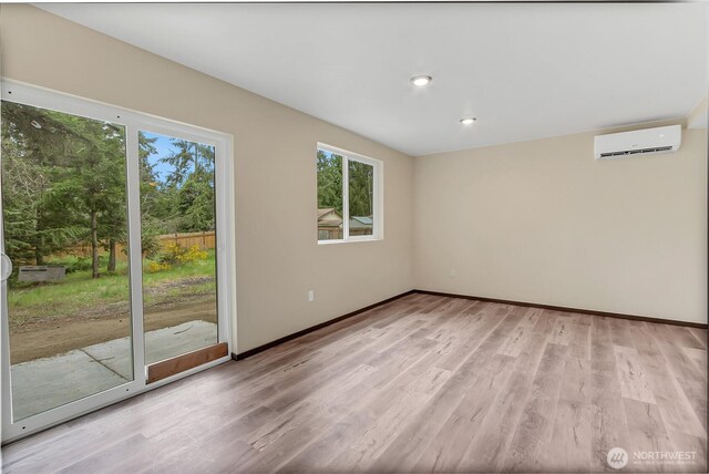 20116 58th Ave E, Spanaway, WA 98387 - unfurnished room with a wall unit AC, plenty of natural light, light wood-type flooring, and baseboards