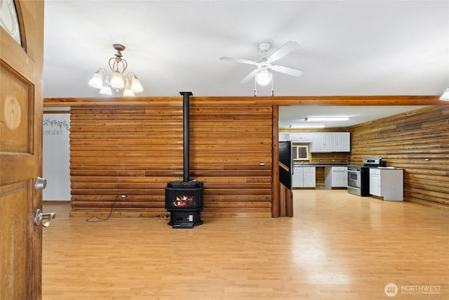 4193 Sparks Rd, Easton, WA 98925 - living room with rustic walls, a wood stove, light wood-type flooring, and ceiling fan