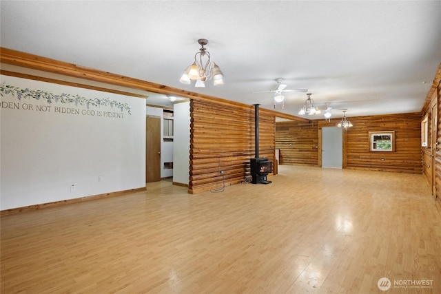 4193 Sparks Rd, Easton, WA 98925 - unfurnished living room featuring log walls, a wood stove, ceiling fan, light wood-type flooring, and a chandelier