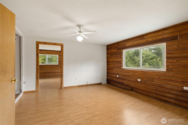 4193 Sparks Rd, Easton, WA 98925 - spare room with light wood-style flooring, plenty of natural light, a ceiling fan, log walls, and baseboards