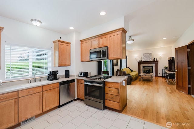3323 Appaloosa Way, Bremerton, WA 98310 - kitchen with appliances with stainless steel finishes, a sink, open floor plan, light countertops, and a fireplace