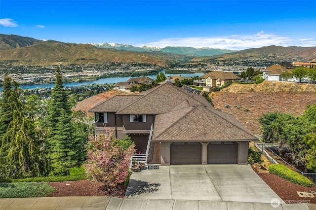2336 Grand Ave, East Wenatchee, WA 98802 - view of front of house with an attached garage, a shingled roof, concrete driveway, and a water and mountain view