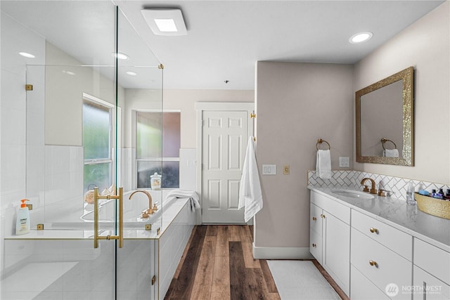2336 Grand Ave, East Wenatchee, WA 98802 - full bathroom featuring vanity, wood finished floors, a garden tub, a stall shower, and baseboards