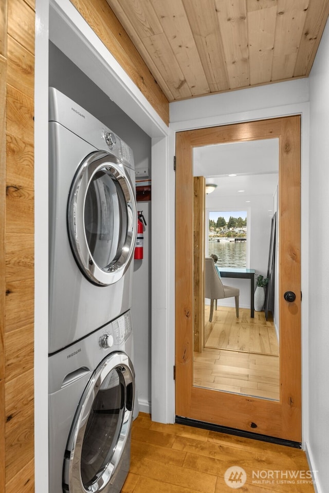 1900 N Westlake Ave N Unit 01Do7, Seattle, WA 98109 - washroom featuring stacked washer and clothes dryer, hardwood / wood-style floors, a water view, and baseboards