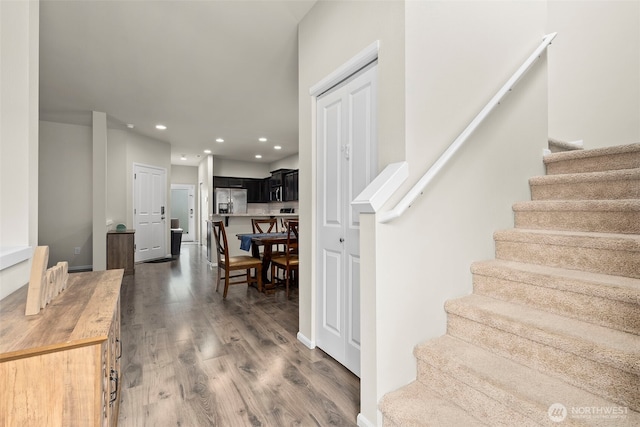 stairway featuring wood finished floors and recessed lighting