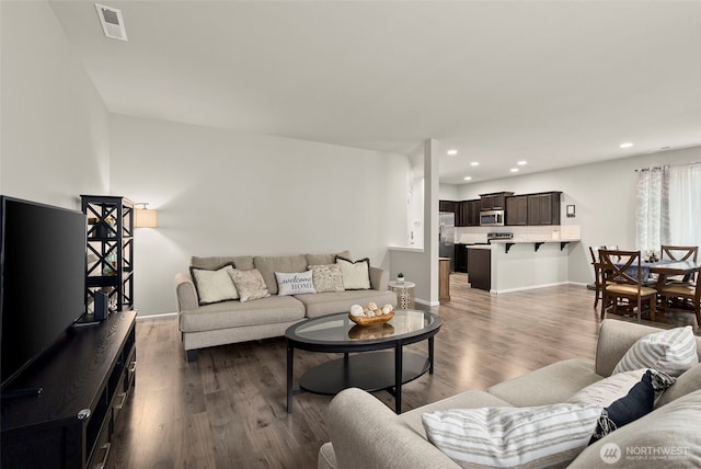 living room with wood finished floors, recessed lighting, and baseboards