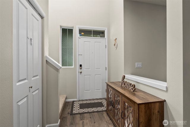 foyer featuring wood finished floors and baseboards