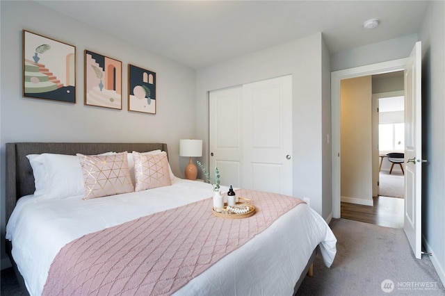 carpeted bedroom featuring a closet and baseboards
